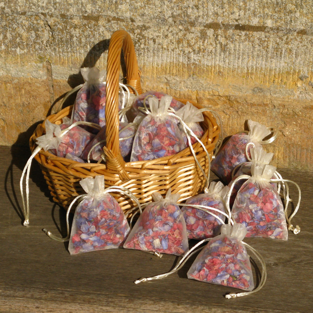An Oval Basket holding Petal Bags filled with Raspberry and Azure Blue Delphinium Petals