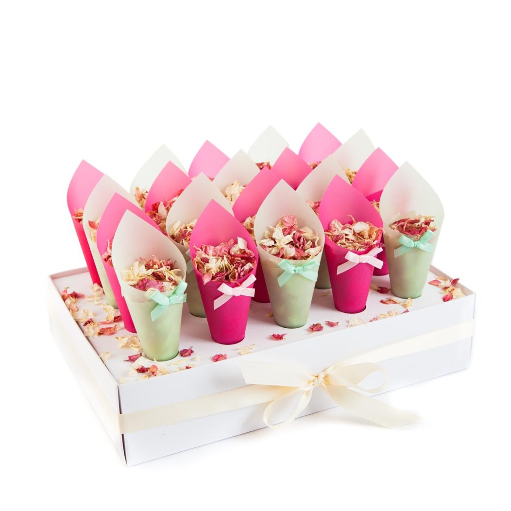 A White Cone Tray with a cream ribbon bow holding Green and Hot Pink Coloured Confetti Cones filled with Raspberry Delphiniums and Magnolia Wildflower petals