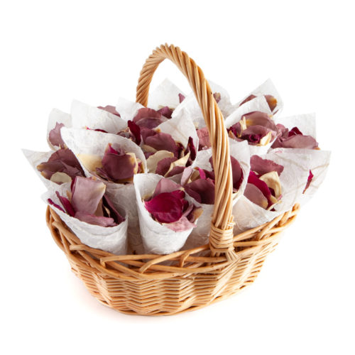 An oval basket filled with confetti cones and rose petals
