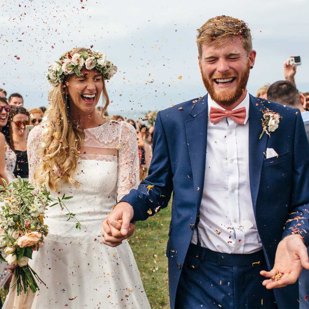 Bride and groom enjoying their real flower petal confetti moment