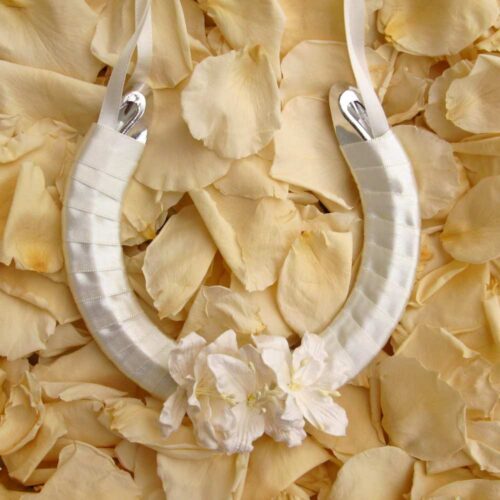 A lucky wedding horseshoe for the bride decorated with large white paper lilies.